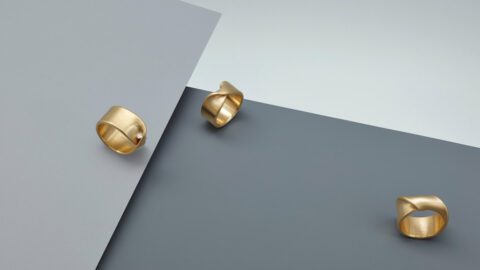 A pair of gold rings on top of a gray surface.